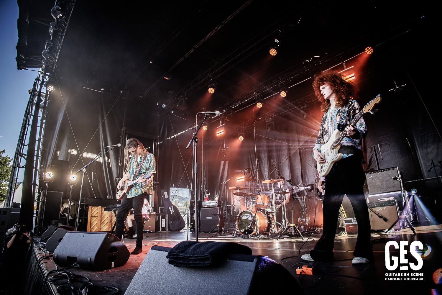 Jesse Bennett and Taj Farrant playing guitar together on a festival stage in France