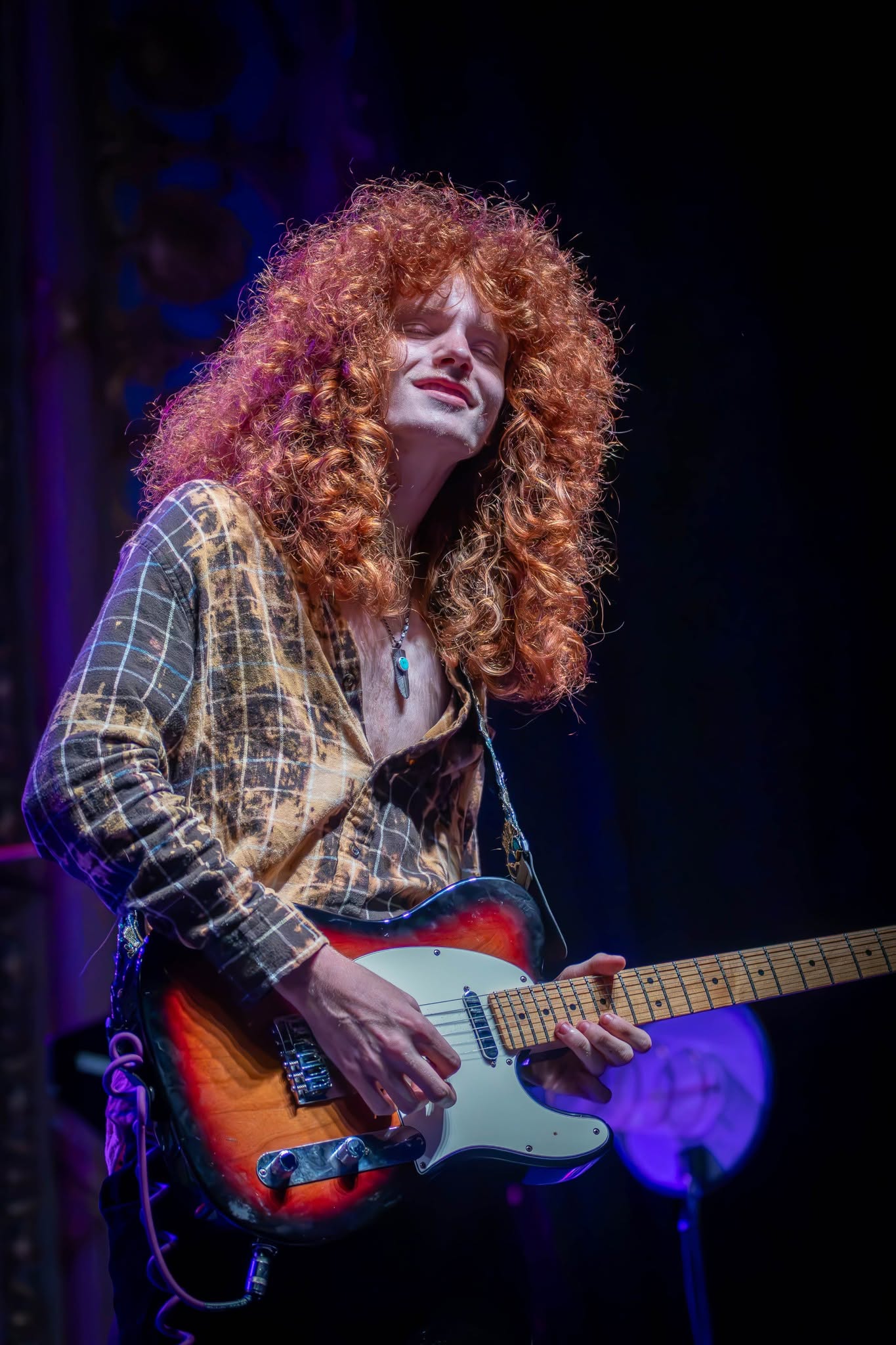 Close-up of Jesse Bennett performing electric guitar onstage
